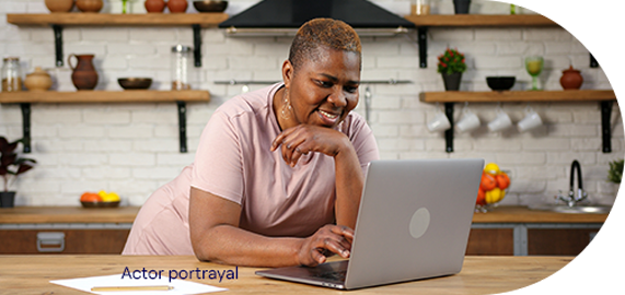 Financial-assistance-woman Woman smiling looking at her laptop